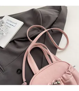 Detailed shot of pink pleated leather bag with silver metal lock and comfortable shoulder strap