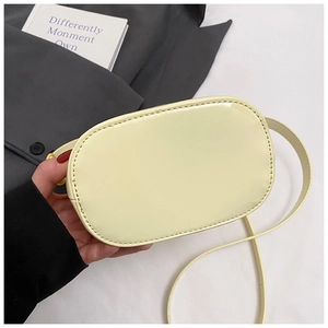 Détail du sac seau beige à motif litchi avec coutures lisses et fine bandoulière réglable
