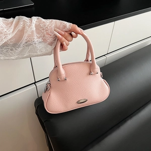 Dettaglio borsa a mano in pelle rosa con texture a grana e fibbia in metallo