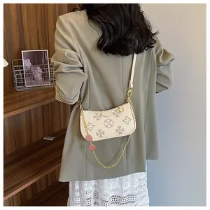 Detail of clover embossed bag with golden chain and pink heart pendants