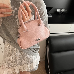 Borsa a mano in pelle rosa a grana litchi con placca in metallo argento vista da vicino