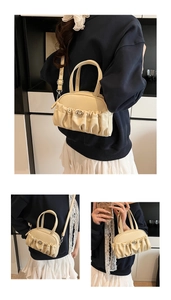 Detail view of cream white pleated pillow bag with top handles and detachable shoulder strap