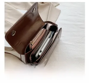 Top view of dark brown crossbody bag interior showing multiple functional compartments