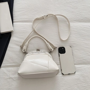Close-up of white vintage kiss-lock handbag with crackle texture and metal clasp
