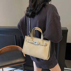 Sac fourre-tout élégant en cuir abricot avec boucle argentée porté à l'épaule