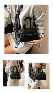 Detail of ruched black pleated handbag featuring a silver twist-lock and supple PU leather