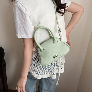 Dettaglio della borsa in pelle verde pistacchio che mostra la trama e la fibbia in metallo