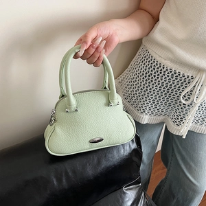 Dettaglio della borsa in pelle martellata verde chiaro con cerniera argentata