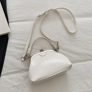 Detail of white crocodile embossed doctor bag with vintage silver clasp and strap