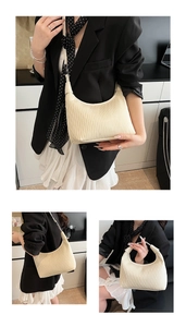 Close-up of cream crescent underarm bag featuring unique wavy pleated texture and slim strap