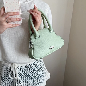 Dettaglio borsa a mano in pelle litchi verde chiaro con placca ovale in argento
