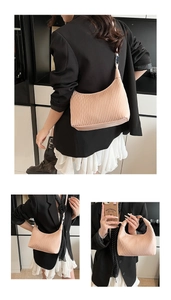Detail of light pink pleated crescent bag showing wavy texture and silver metal buckle