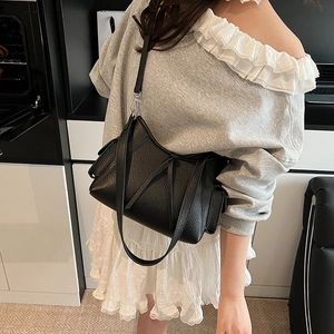 Schwarze Schultertasche aus Leder mit Litschi-Muster am Modell im Urban-Stil