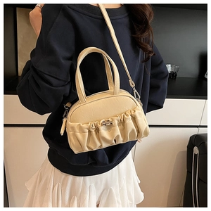 Detail of beige pleated shell bag with detachable strap and elegant handle