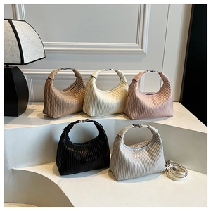Detailed arrangement of five pleated hobo bags with silver buckles on a curved display
