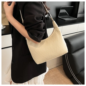 Close-up of beige pleated dumpling bag with wavy texture for casual commuting fashion