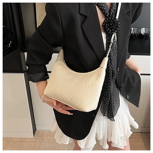 Detail of beige hobo bag showing pleated texture and vertical fold craftsmanship on PU leather