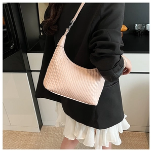 Detail of light pink pleated shoulder bag with adjustable strap shown on model