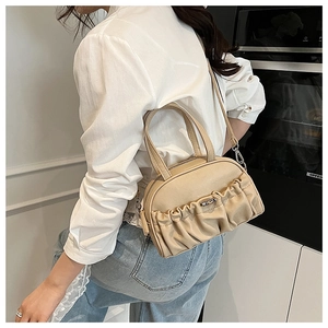 Detail view of the beige pleated leather handbag with stylish silver metal twist lock