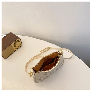 Detail view of the cream shoulder bag with grey floral patterns and brown fabric lining