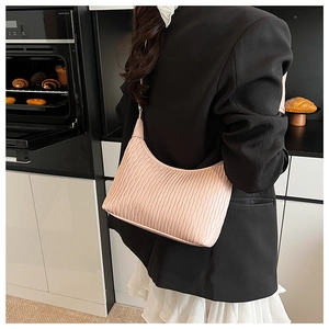 Detailed close-up of a pink pleated hobo shoulder bag with a stylish textured surface