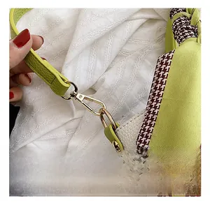 Macro shot of gold metal swivel hook and neon green pebbled leather strap on retro bag