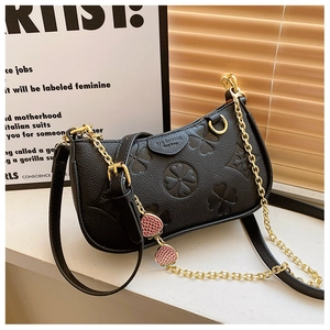 Detail of black embossed clover handbag with strawberry charms and gold chain strap