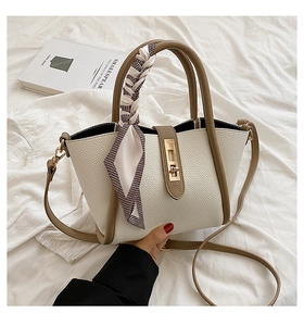 Detail of two-tone faux leather tote bag with silk scarf handle and golden twist lock