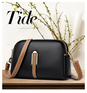 Macro detail of black lychee grain leather shell bag with brown contrast stitching strap