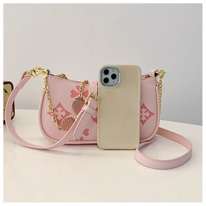 Pink embossed clover crossbody bag with strawberry pendant and chain strap detail