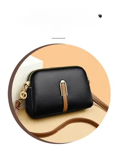 Close-up of black lychee grain leather camera bag with dual zippers and gold hardware