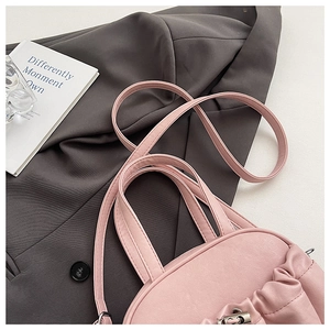 Close-up of pink pleated PU leather handbag featuring a silver metallic twist lock closure