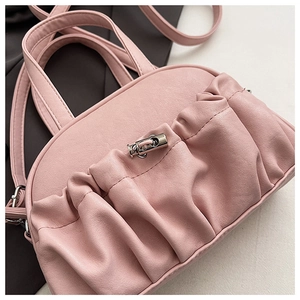 Detailed close-up of pink pleated PU leather handbag showing texture and silver metal clasp