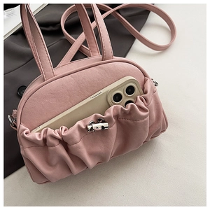 Detailed view of pink pleated handbag with silver clasp and phone storage pocket