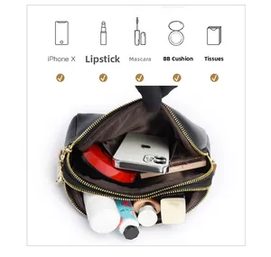 Detail of black leather shell bag with gold zippers and organized internal storage compartments