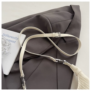 Detailed view of cream-white pleated handbag with adjustable silver-tone metal buckle