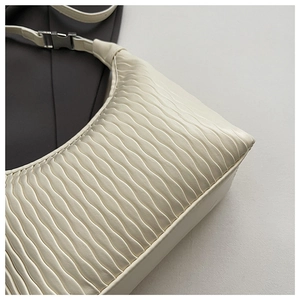 Detail shot of beige shoulder bag showing unique wave ripple texture and PU leather material