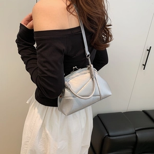 Detail of silver metallic frame bag with doctor bag clasp and cylindrical handle
