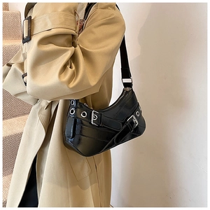 Detail showing the silver buckles and metal eyelets on the black motorcycle shoulder bag