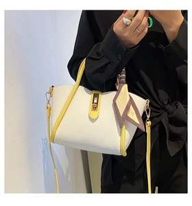 Detailed close-up of white lychee leather handbag with yellow handle and stylish silk scarf