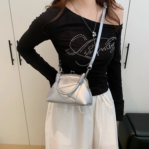 Detail of silver vintage-style frame bag featuring pleated synthetic leather and spiral handle
