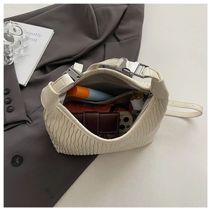 Top view of cream pleated handbag interior showing large capacity for phone and makeup