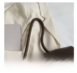 Detailed close-up of brown crocodile texture leather tote bag handle and surface