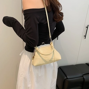Detail of cream vintage frame bag with textured stitching and braided top handle