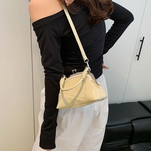Close-up of cream leather bag featuring a retro metal clasp and knot handle detail