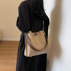 Stylish khaki large capacity bucket bag with brown straps and gold metal feet detail