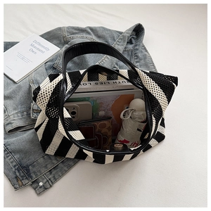 Spacious black and white striped tote bag showing capacity for books, umbrella and phone