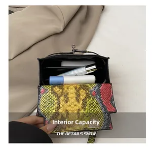 Internal capacity of the snake pattern mini handbag showing phone and cosmetics