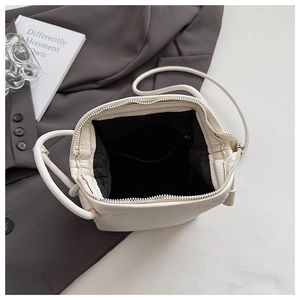 Top view of white shell bag showing lychee grain texture and internal zipper pocket