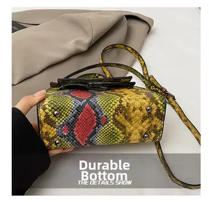 Detail of colorful snakeskin pattern bag base with four protective metal feet